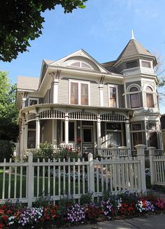 a white picket fence in front of a large house