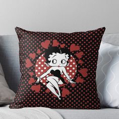 a black and red polka doted pillow with a cartoon girl on it's face