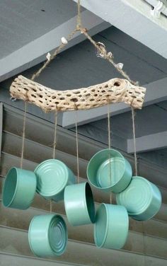 some green cups hanging from a wooden branch