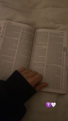 someone is reading a book with their hand on top of the book and holding it up