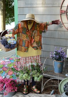 a woman standing in front of a house with her arms spread out and holding flowers