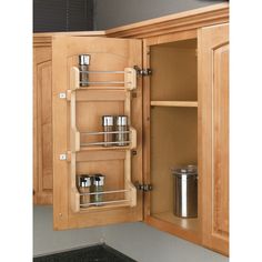 an open cabinet door with spice racks in it