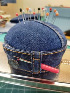 a denim cap with pins sticking out of it