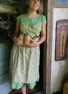 a woman standing in front of a door holding two jars with food inside of them