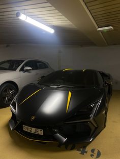 two sports cars parked in a garage next to each other