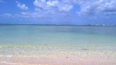 the ocean is clear and blue with white clouds