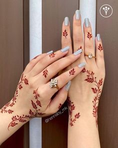 two hands with hendi designs on their fingers and one hand holding the other's finger