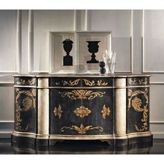 an ornate black and gold sideboard with two vases on it's sides