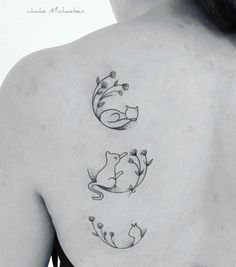 the back of a woman's shoulder with three cats and flowers on her left side