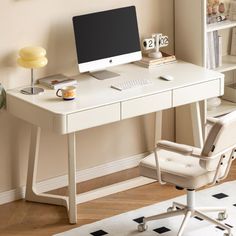 a white desk with a computer on it in front of a bookcase and window