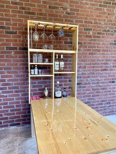 a wooden table sitting in front of a brick wall