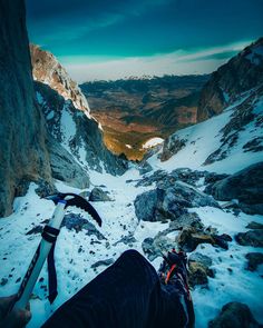 a person with skis standing on top of a snow covered mountain