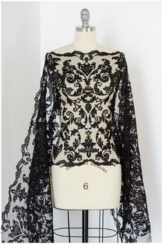 a mannequin with black lace on it and a white dress form behind it