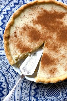 a pie on a plate with a piece missing from it and a serving utensil