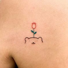 a small tattoo on the back of a woman's shoulder with a flower in it