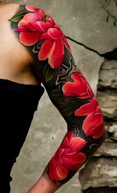 a woman wearing a black top with red flowers on her arm