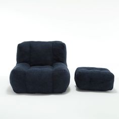 a blue chair and ottoman sitting next to each other on a white surface with one foot in the air