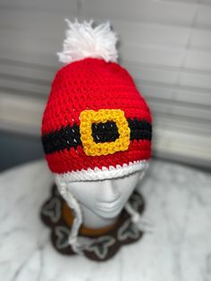 a knitted hat with a yellow and black eye patch on top of a mannequin's head