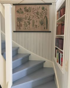 there is a blue stair case in the house with bookshelves on either side