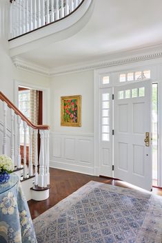 a large white room with wooden floors and stairs