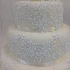 two tiered wedding cake with white lace and bows