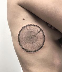 a close up of a person's thigh with a tree ring tattoo on it