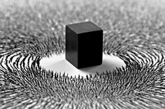 a black cube sitting on top of a white floor covered in lots of small lines