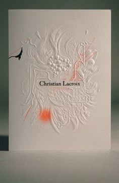 a white card with an orange marker on it that says christian larroie in the center