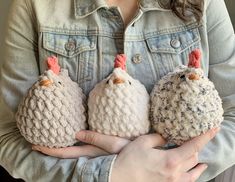 three crocheted chickens are held in their hands