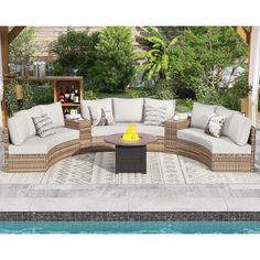 an outdoor living area with couches, tables and a fire pit in the middle