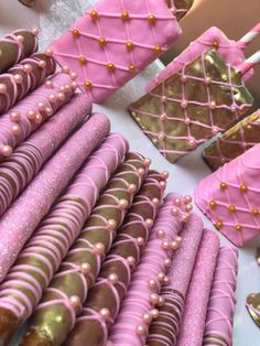 pink and gold desserts are arranged on a table