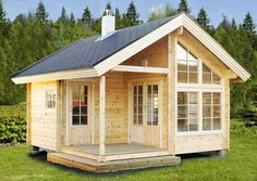 a small wooden cabin sitting on top of a lush green field