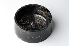 a black and gold marbled bowl on a white background with the words royal friend written in gold