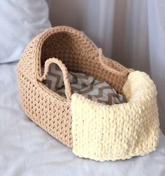 a crocheted basket is sitting on a bed