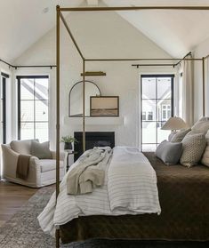 a bedroom with a four poster bed and white walls