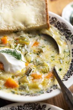 a bowl of soup with bread and sour cream