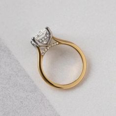 a gold and white diamond ring sitting on top of a table