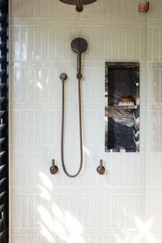 a bathroom with a shower head and hand held shower faucet