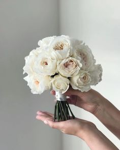 a person holding a bouquet of white flowers