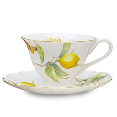 a tea cup and saucer with lemons on the rim, set against a white background