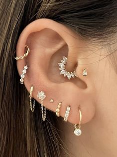 a woman's ear with three different types of piercings on it and one is attached