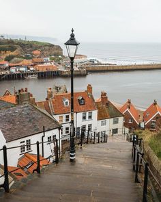 a street light on the side of a road next to some buildings and a body of water