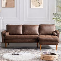 a brown leather couch sitting on top of a rug