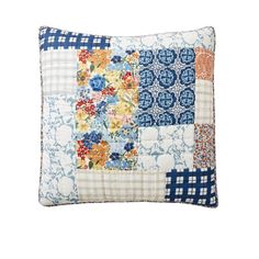 a blue and white patchwork pillow with flowers on it's side, against a white background