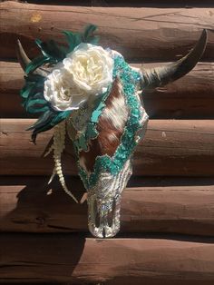 a cow skull decorated with flowers and feathers