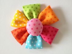 a colorful polka dot hair bow on a white background