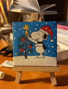 a painting of a dog with a santa hat on it's head is sitting on an easel