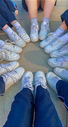 a group of people sitting in a circle wearing tennis shoes