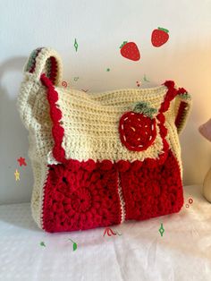 a crocheted purse sitting on top of a bed next to a stuffed animal