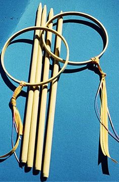 four wooden sticks with tassels attached to them on a blue surface, against a bright blue sky